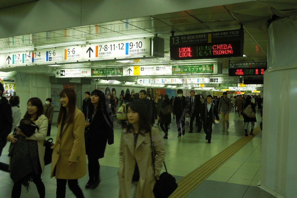 Busy station in Tokyo with indication of several train lines and exits